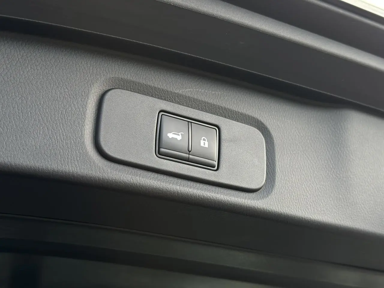 Boutons de hayon électrique et verrouillage intégrés dans le panneau intérieur du coffre du Nissan Qashqai noir nacré 2025.