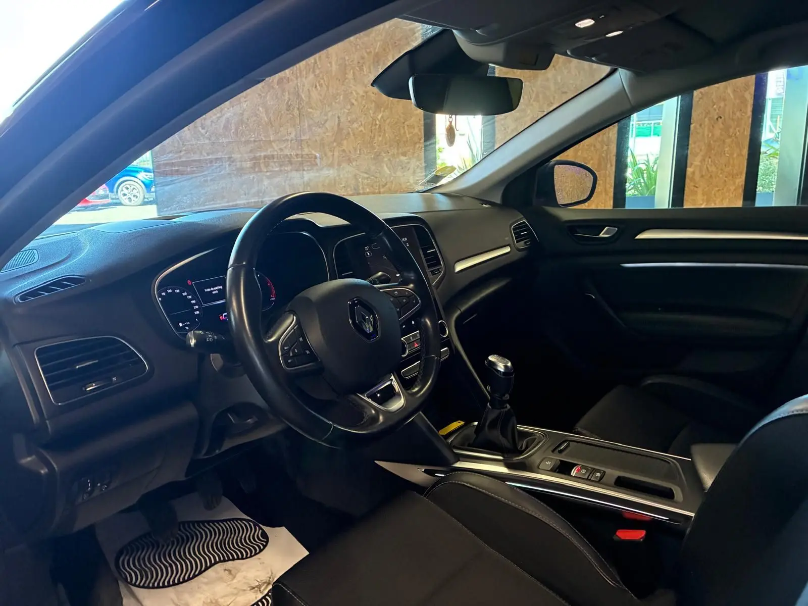 Intérieur avant droit de la Renault Mégane 1.5 DCI 115 Intens 2021, volant cuir, boîte manuelle et tableau de bord moderne.