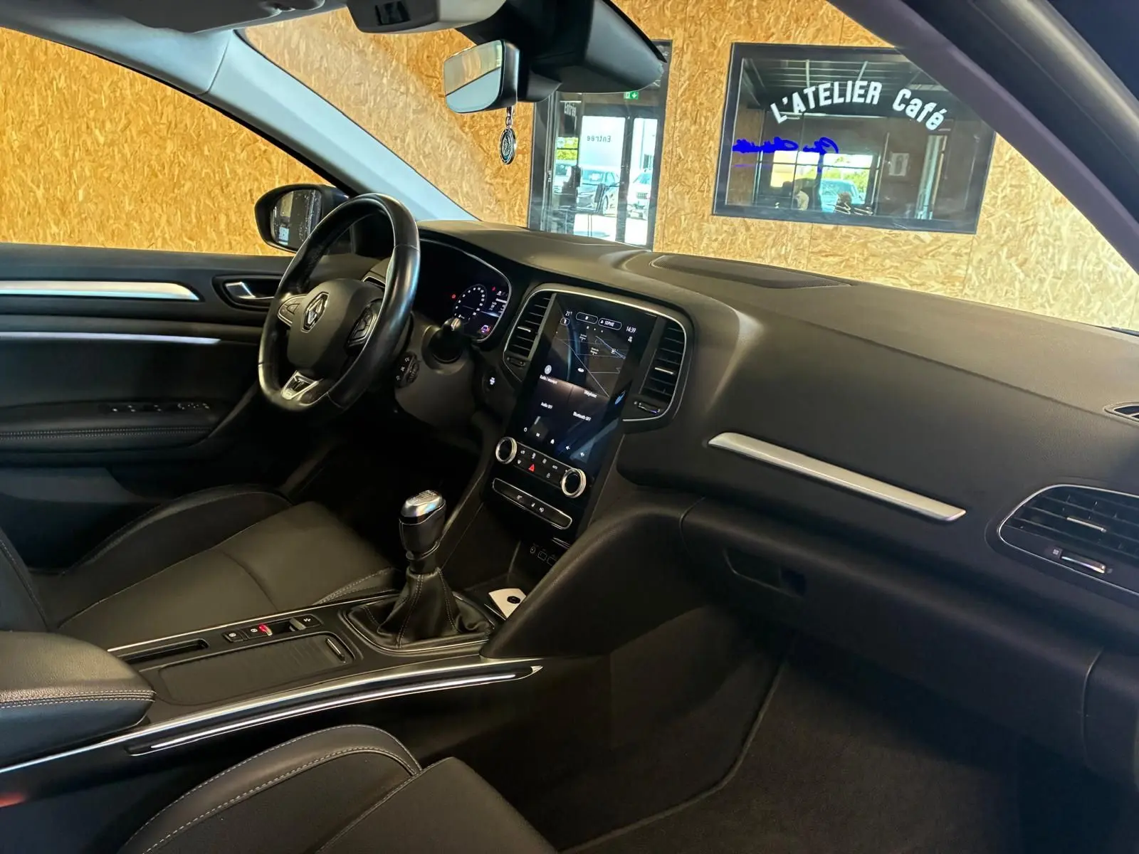 Intérieur avant droit d'une Renault Mégane 1.5 DCI 115 Intens 2021 avec tableau de bord noir et boîte manuelle.