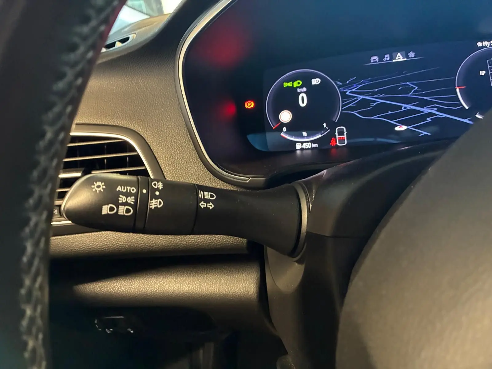 Gros plan sur la manette des phares et le tableau de bord numérique de la Renault Mégane 1.5 DCI 115 Intens 2021.