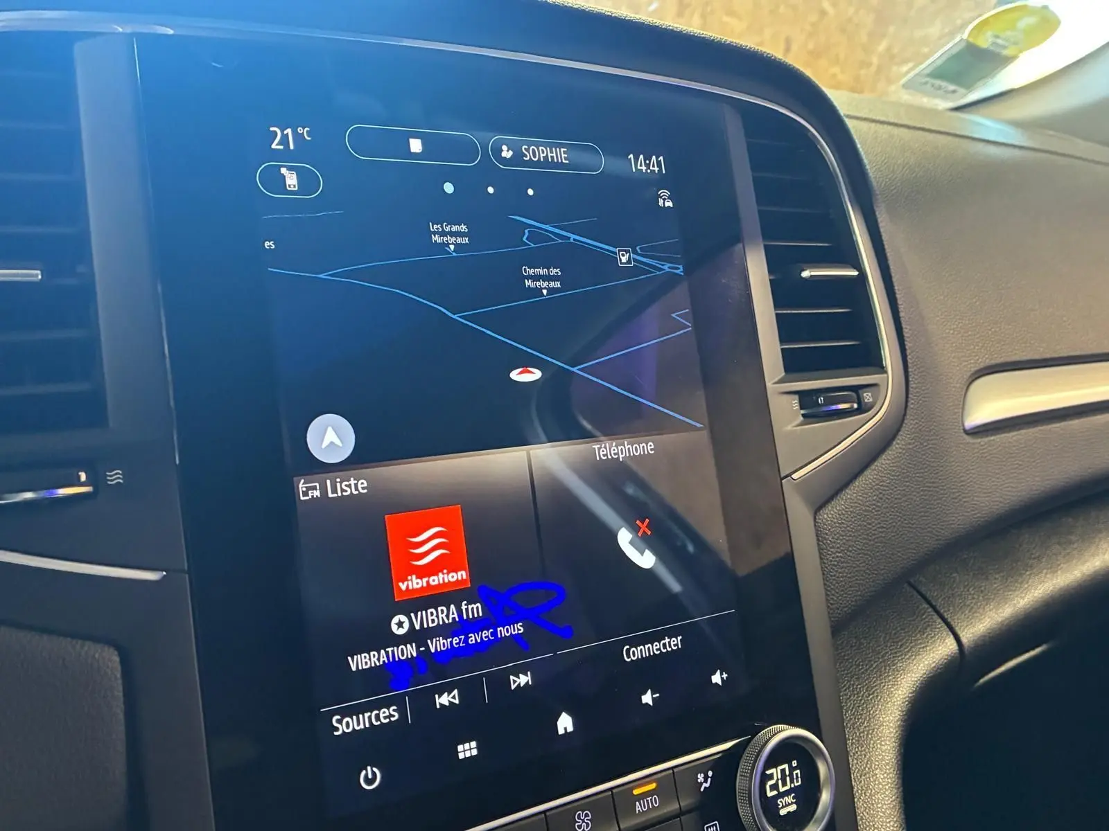 Écran tactile central de la Renault Mégane 1.5 DCI bleu, affichant navigation et radio VIBRA fm, vue intérieure côté passager.