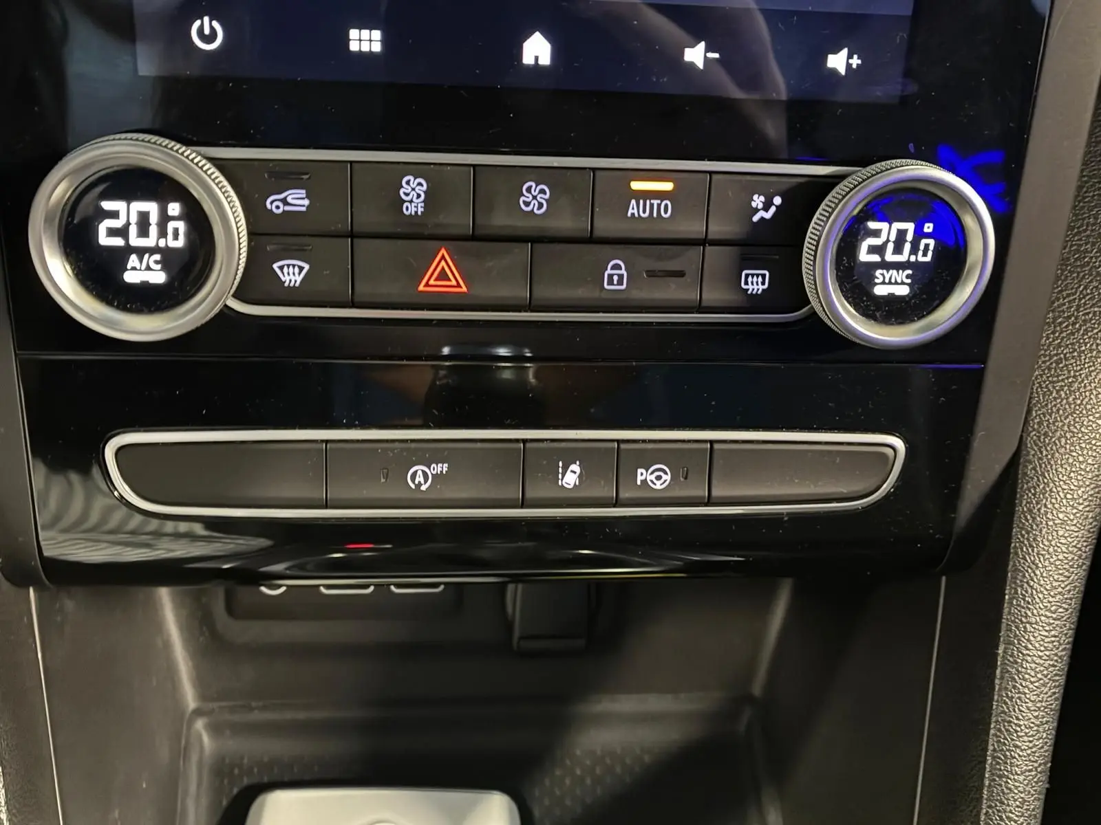 Gros plan sur la console centrale de la Renault Mégane 1.5 DCI 115 Intens 2021, avec commandes climatisation et boutons fonctionnels.