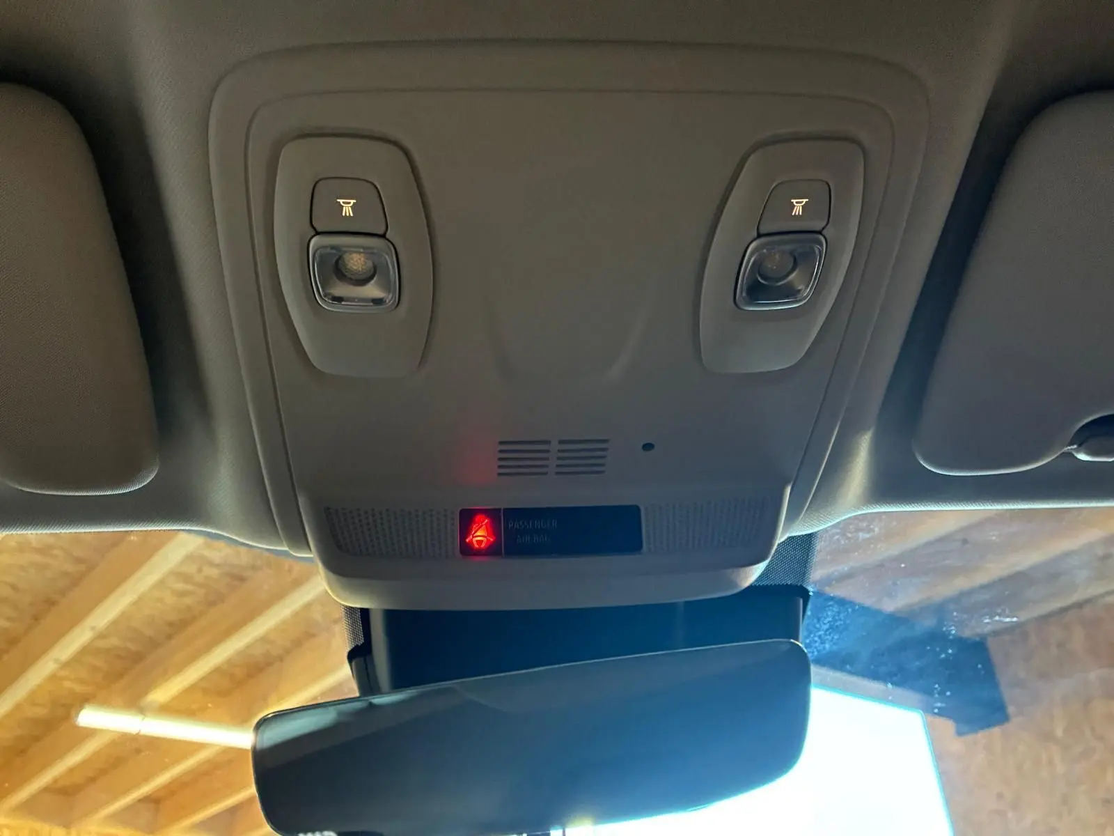 Vue intérieure du plafonnier gris clair de la Renault Mégane 1.5 DCI 115 Intens avec éclairages de lecture et témoin airbag passager.