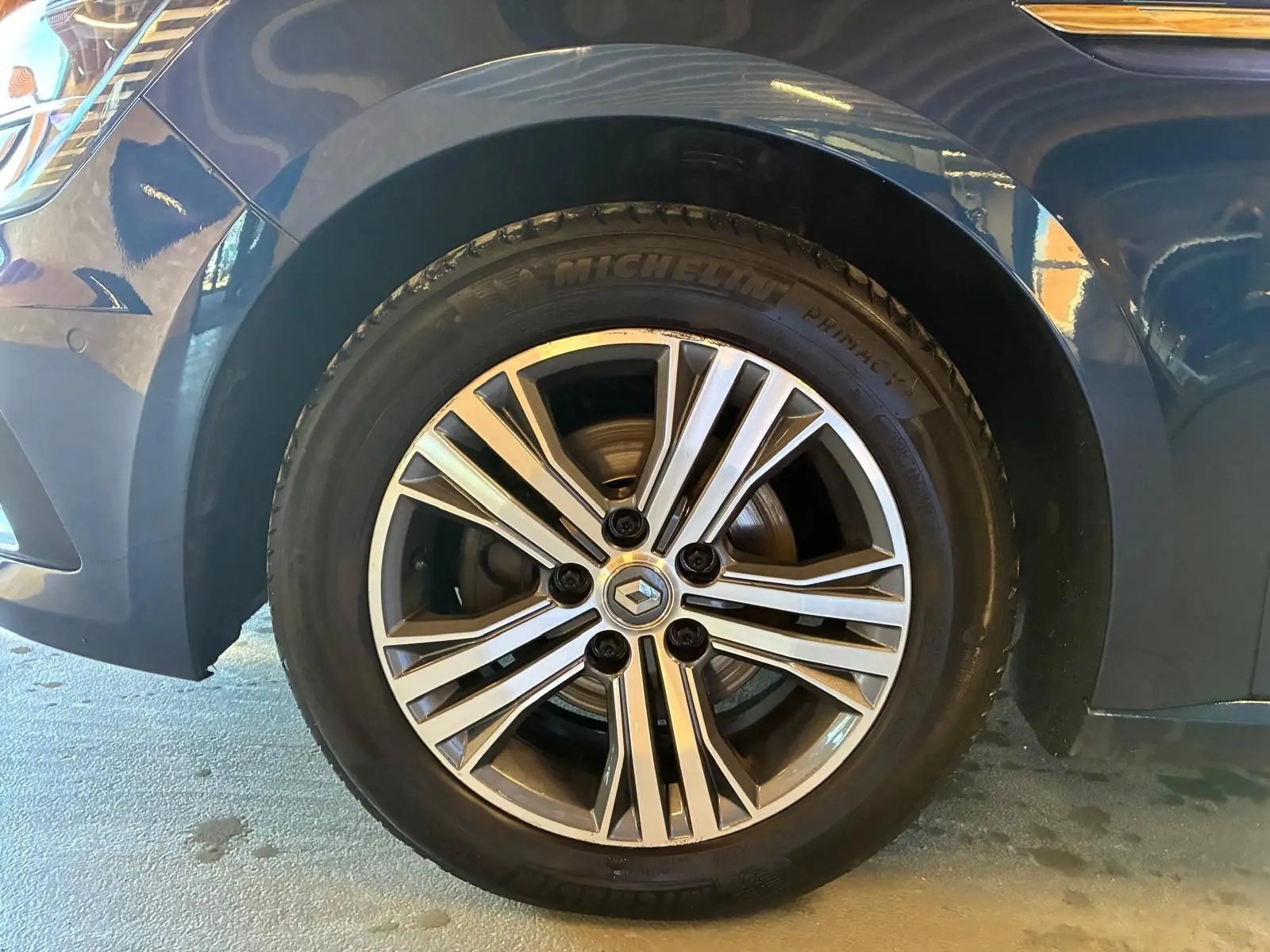 Gros plan sur la roue avant gauche d'une Renault Mégane bleu 2021 avec jante alliage et pneu Michelin.