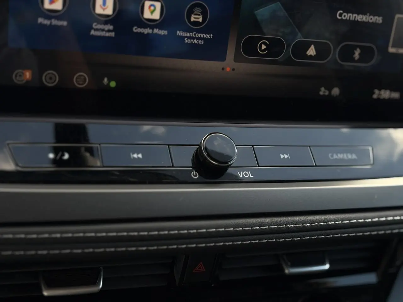 Gros plan sur la molette de volume et les commandes multimédia du tableau de bord du Nissan Qashqai gris argent 2025.