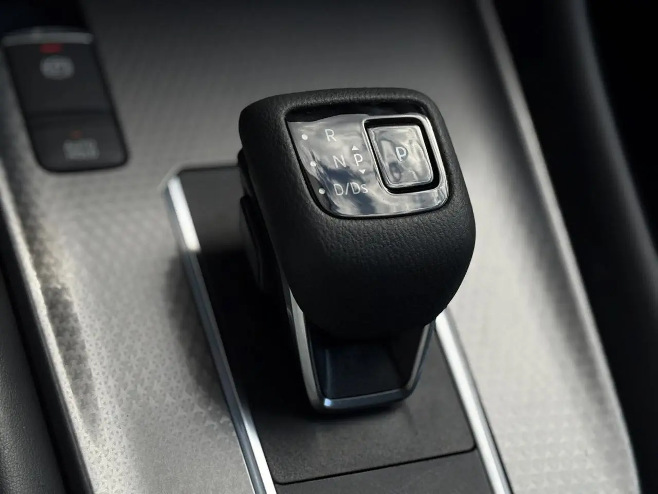 Le levier de vitesses automatique noir du Nissan Qashqai 2025 vu en gros plan sur console argentée.