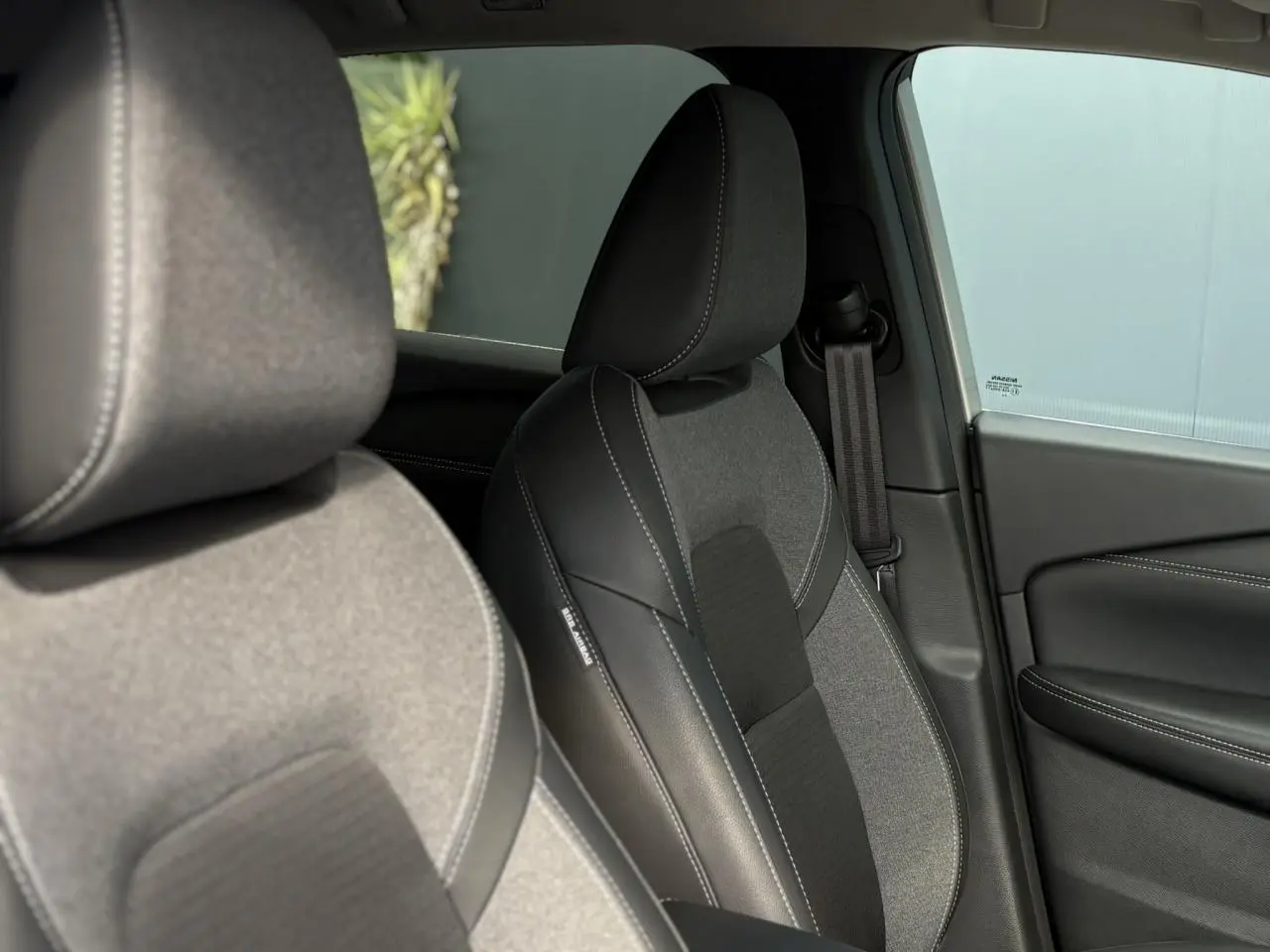 Gros plan sur les sièges avant en sellerie mixte noir tissu et TEP du Nissan Qashqai 2025, côté droit intérieur.
