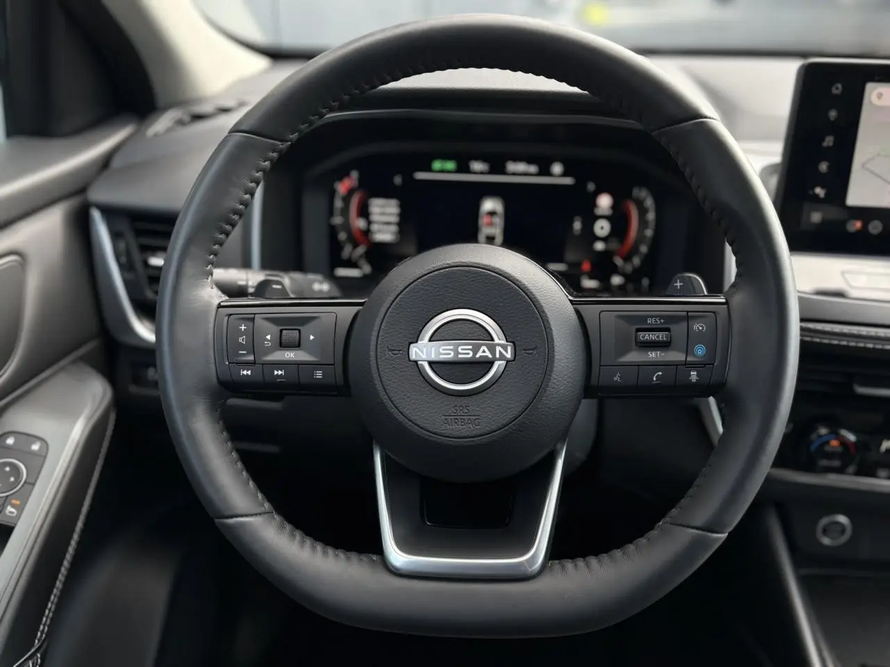 Volant cuir noir Nissan Qashqai 2025 vu de face avec commandes intégrées et tableau de bord numérique.