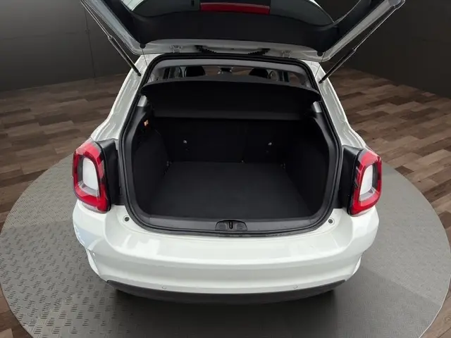 Vue arrière ouverte du coffre d'une FIAT 500X blanche 2023, montrant l'espace de chargement et le hayon relevé.