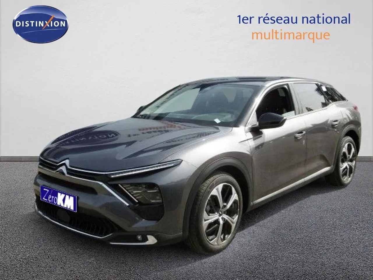 Vue 3/4 avant d'une Citroën C5 X gris platinium métal avec jantes bi-ton et calandre distinctive moderne.