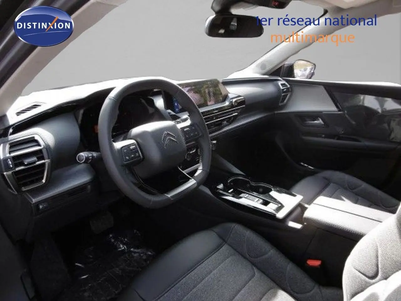 Intérieur noir de la Citroën C5 X 2023, vue côté conducteur avec tableau de bord moderne et volant multifonction.