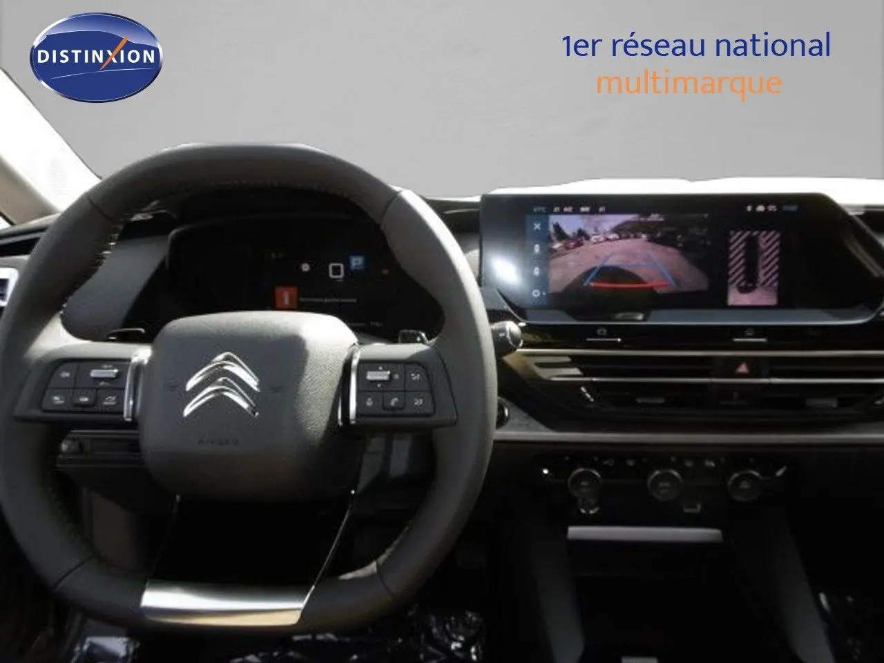 Vue intérieure du tableau de bord et volant Citroën C5 X 2023, avec écran tactile affichant la caméra de recul.