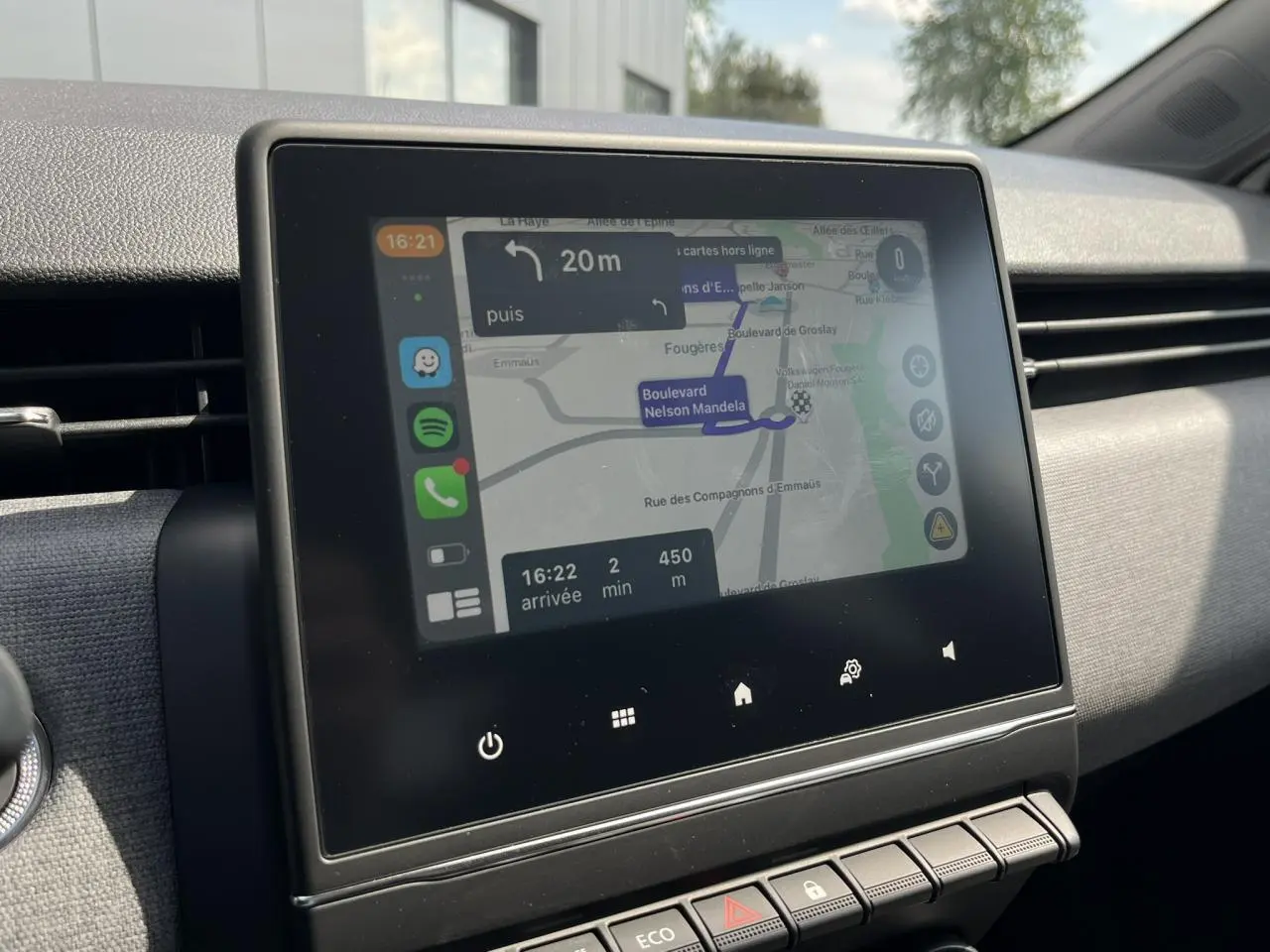 Écran tactile central de la Renault Clio 2025 affichant la navigation sur fond de tableau de bord gris.