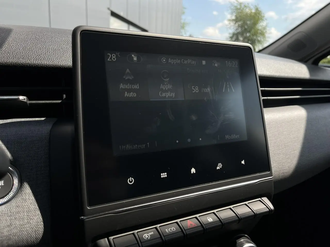 Écran tactile central de la Renault Clio 2025 affichant Android Auto et Apple CarPlay dans un intérieur sombre.