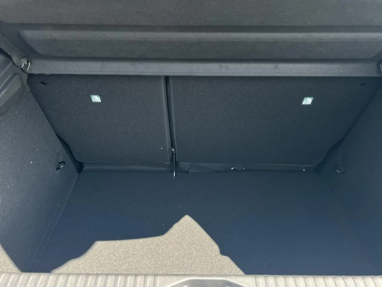 Coffre spacieux et vide de la Renault Clio 2025 blanc glacier, vue intérieure arrière avec banquette rabattue.