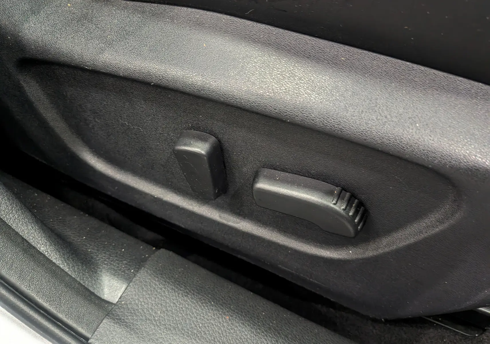 Commandes électriques noires du réglage de siège côté conducteur du Nissan Qashqai gris perle 2018.