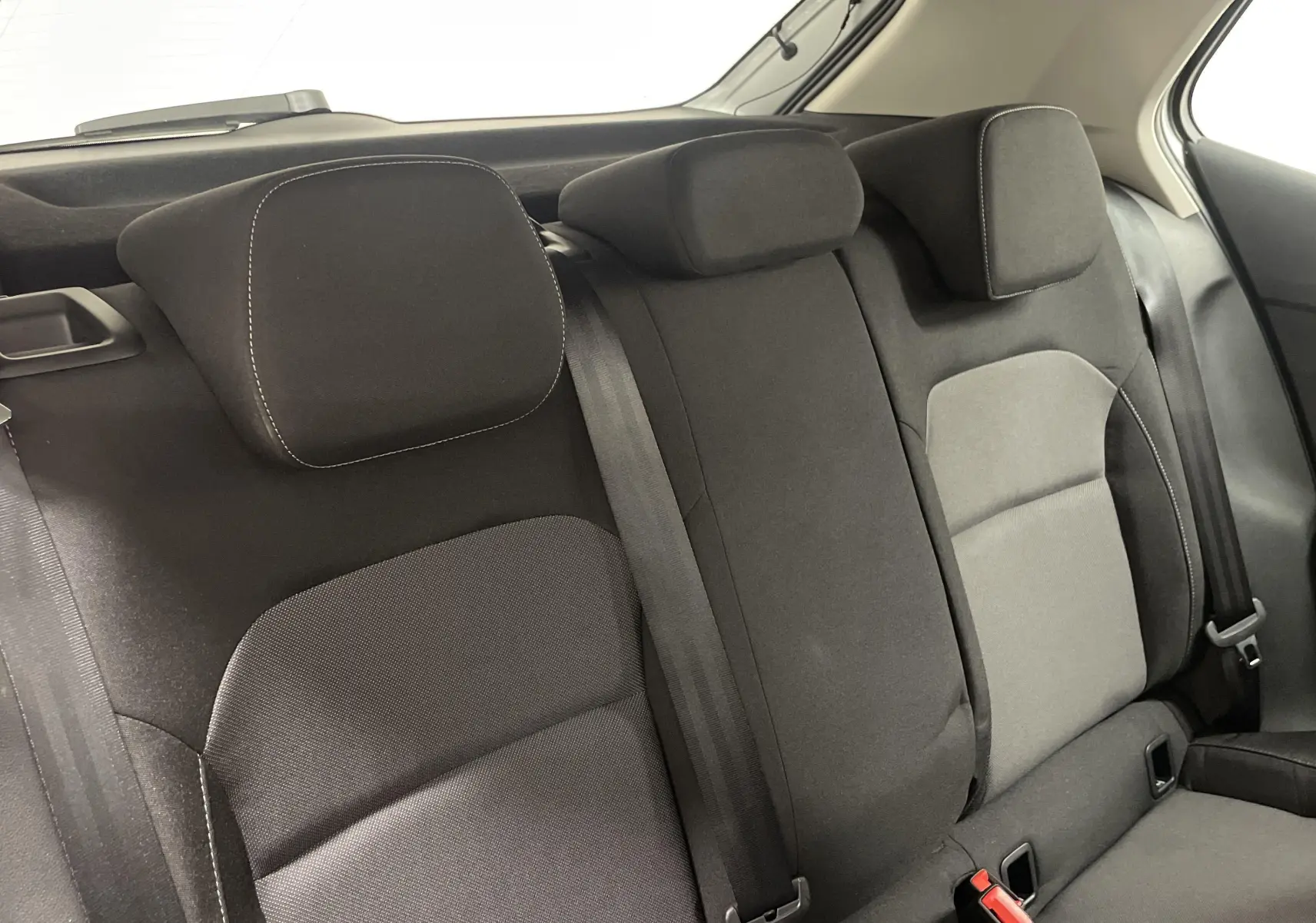 Vue rapprochée des sièges arrière noirs avec appuie-têtes et ceintures de sécurité d'une Skoda Fabia 2025.