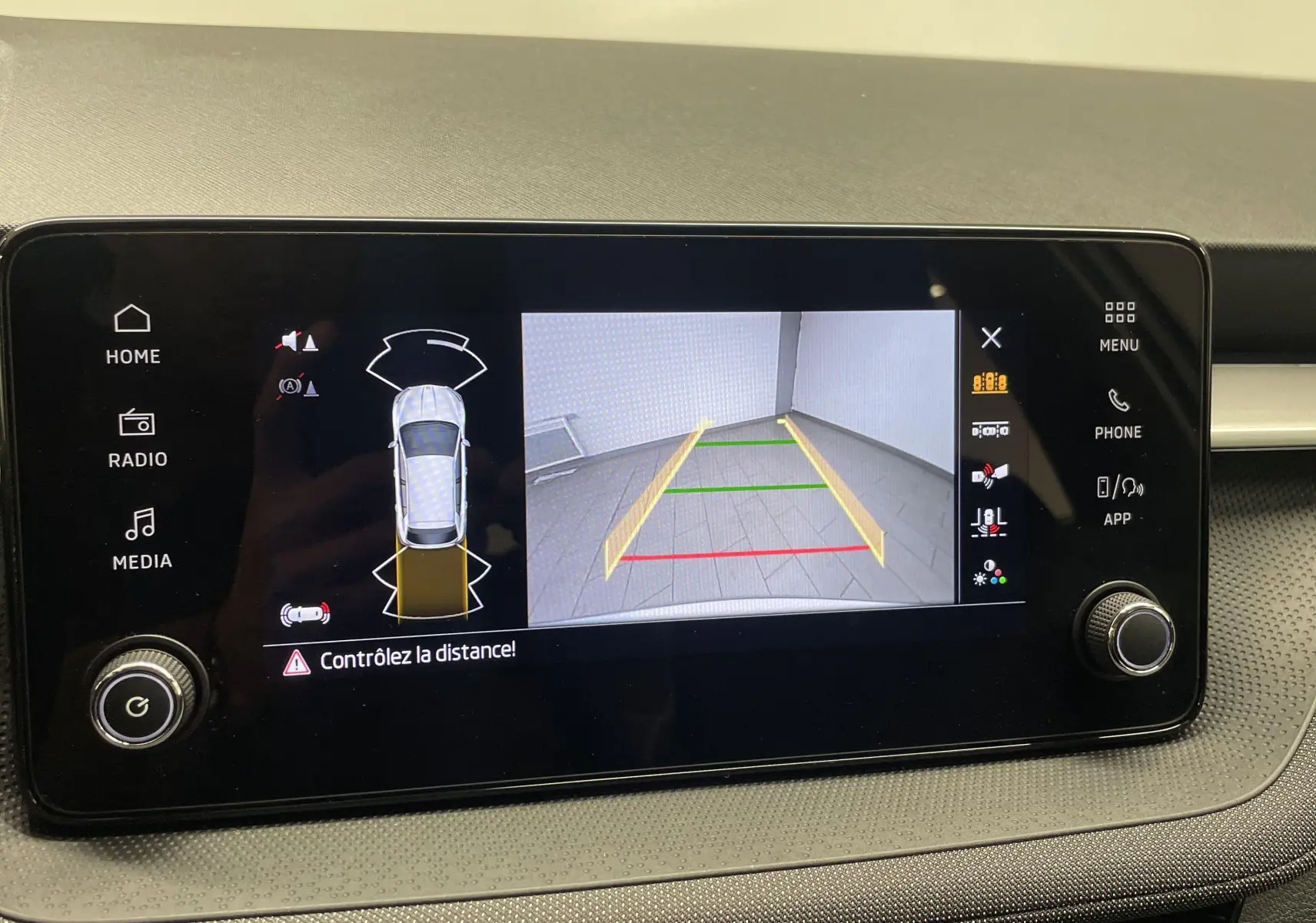 Écran multimédia de la Skoda Fabia gris argent 2025 montrant la caméra de recul et radars de stationnement actifs