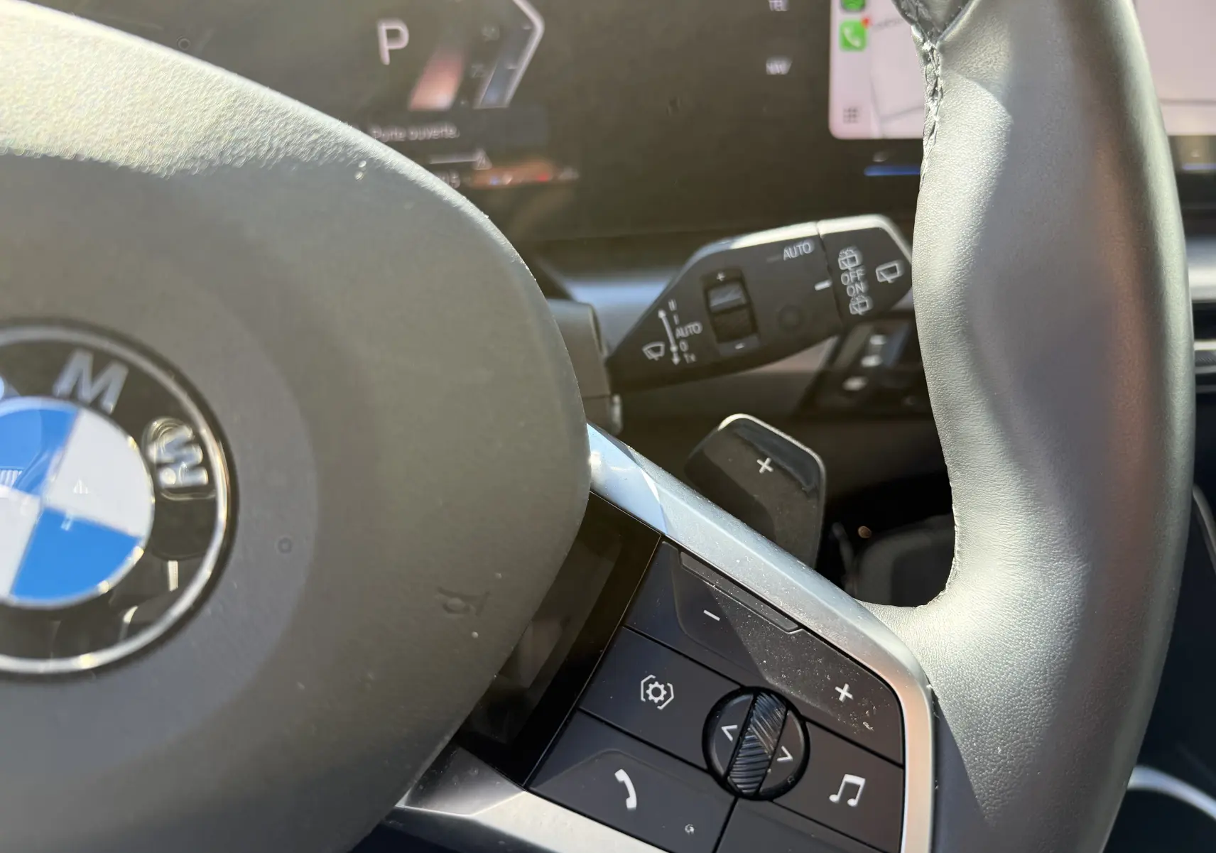 Gros plan sur le volant cuir noir de la BMW X1 20D 163CH M SPORT 2025 avec commandes multifonctions et palettes au volant.