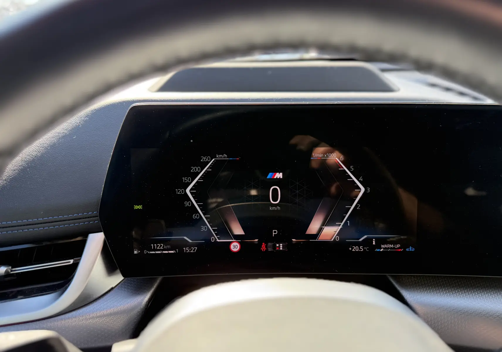 Tableau de bord numérique de BMW X1 20D M Sport 2025, affichage vitesse et compte-tours, ambiance intérieure sombre.