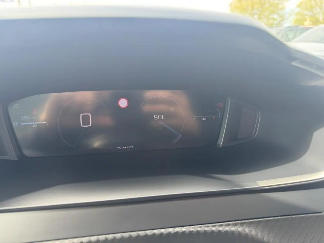 Vue rapprochée du cockpit numérique du Peugeot 2008 2024, affichant la vitesse à zéro et le compte-tours à 900 tr/min.