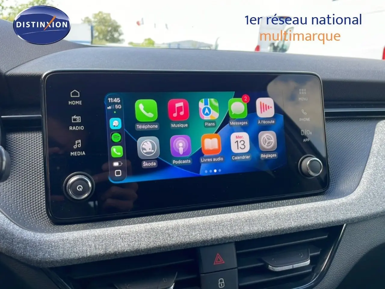 Écran tactile central de la Skoda Scala 2025 affichant l'interface Apple CarPlay avec commandes autour.