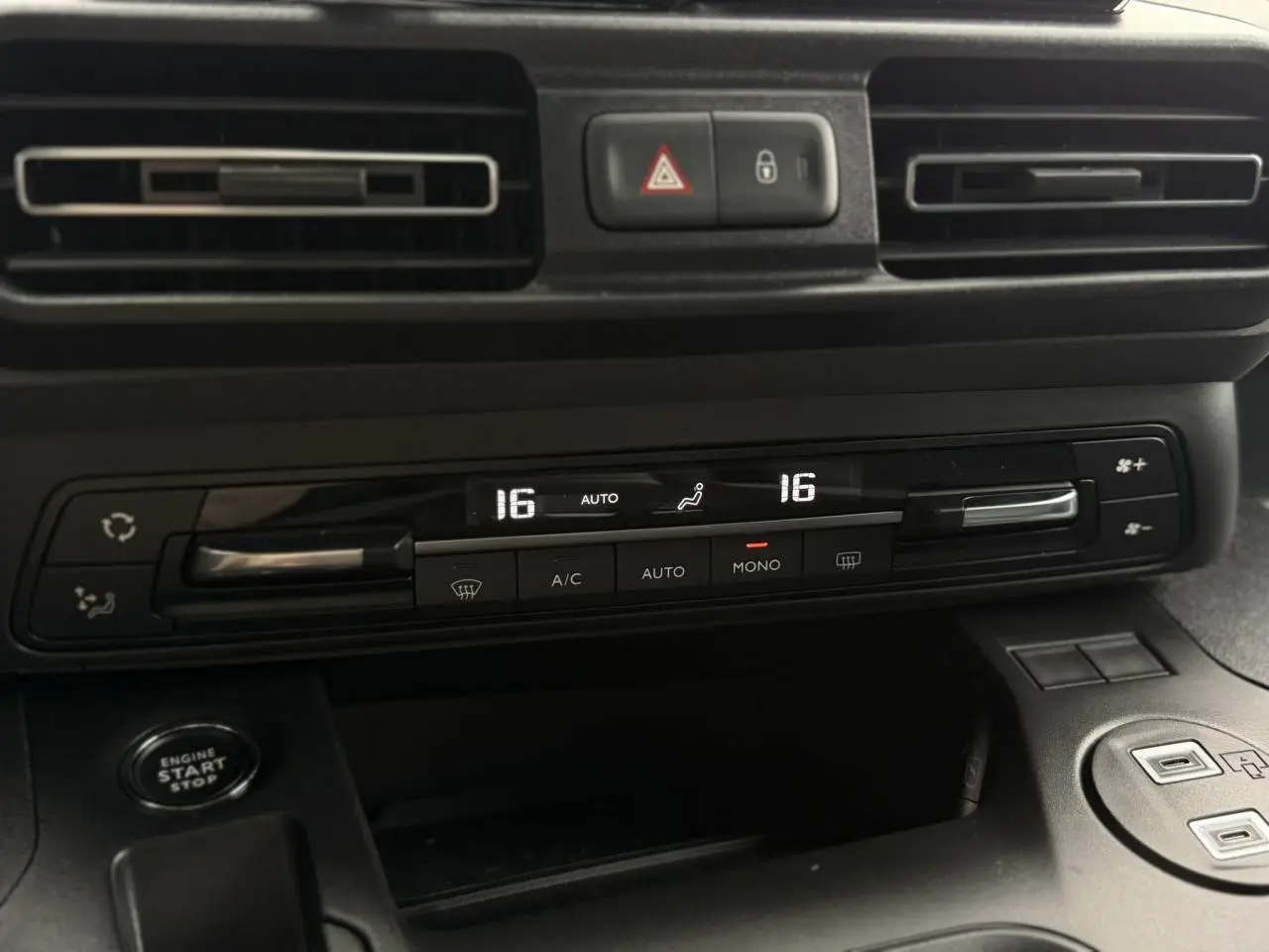 Détail du tableau de bord du Peugeot Rifter gris acier 2026, montrant la climatisation automatique bi-zone et bouton start/stop.