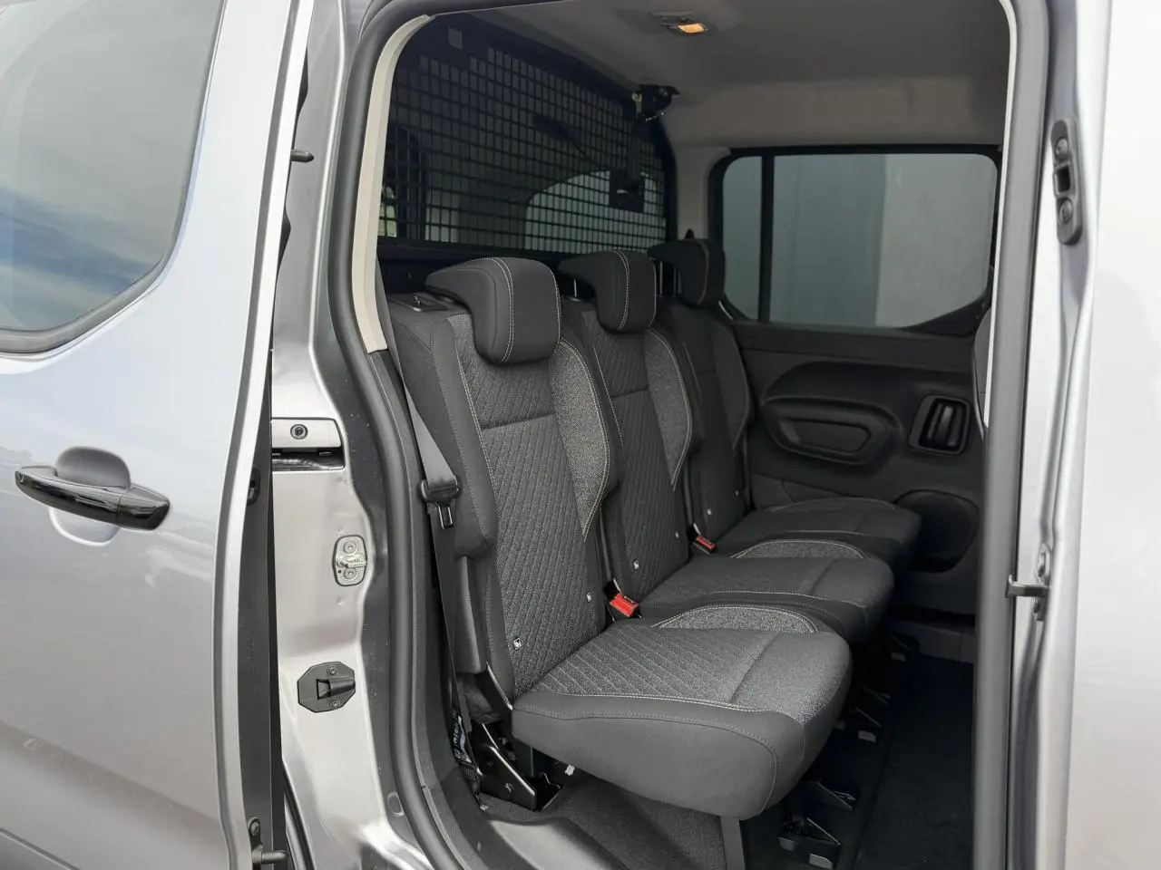 Vue intérieure côté droit du Peugeot Rifter gris acier 2026, montrant les trois sièges individuels en rang 2 avec appuie-têtes.
