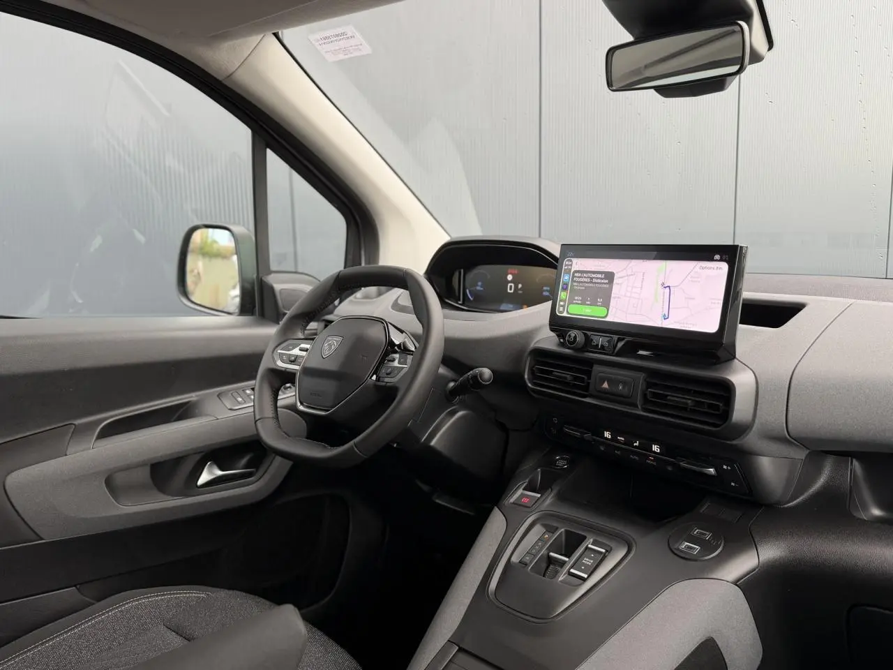 Vue intérieure côté conducteur du Peugeot Rifter 2026 avec tableau de bord numérique et écran tactile de navigation.