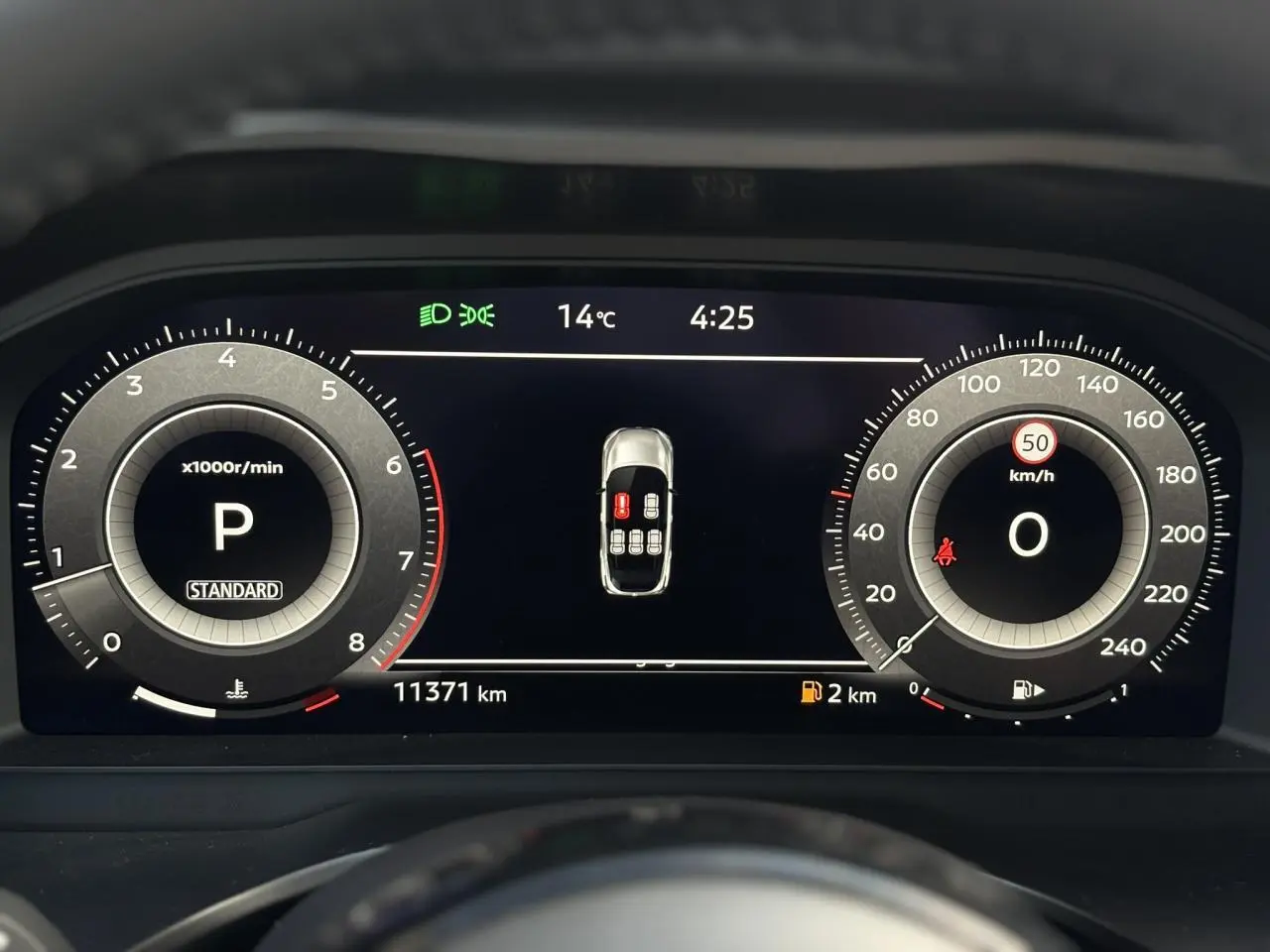 Affichage numérique du tableau de bord du Nissan Qashqai 2025, indiquant la vitesse, régime et alertes de porte ouverte.