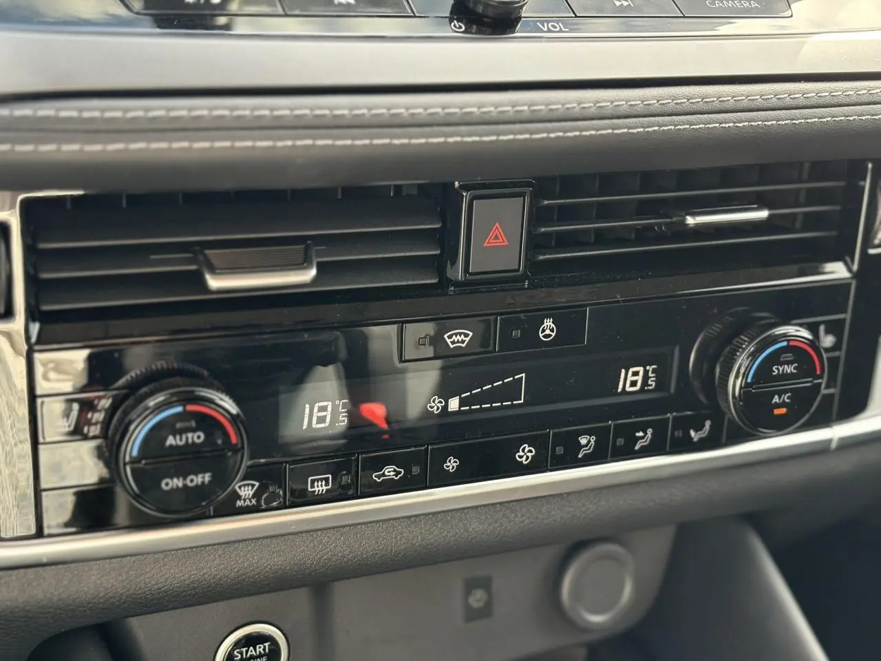 Détail de la console centrale noire du Nissan Qashqai 2025 avec commandes de climatisation bi-zone et bouton de démarrage.