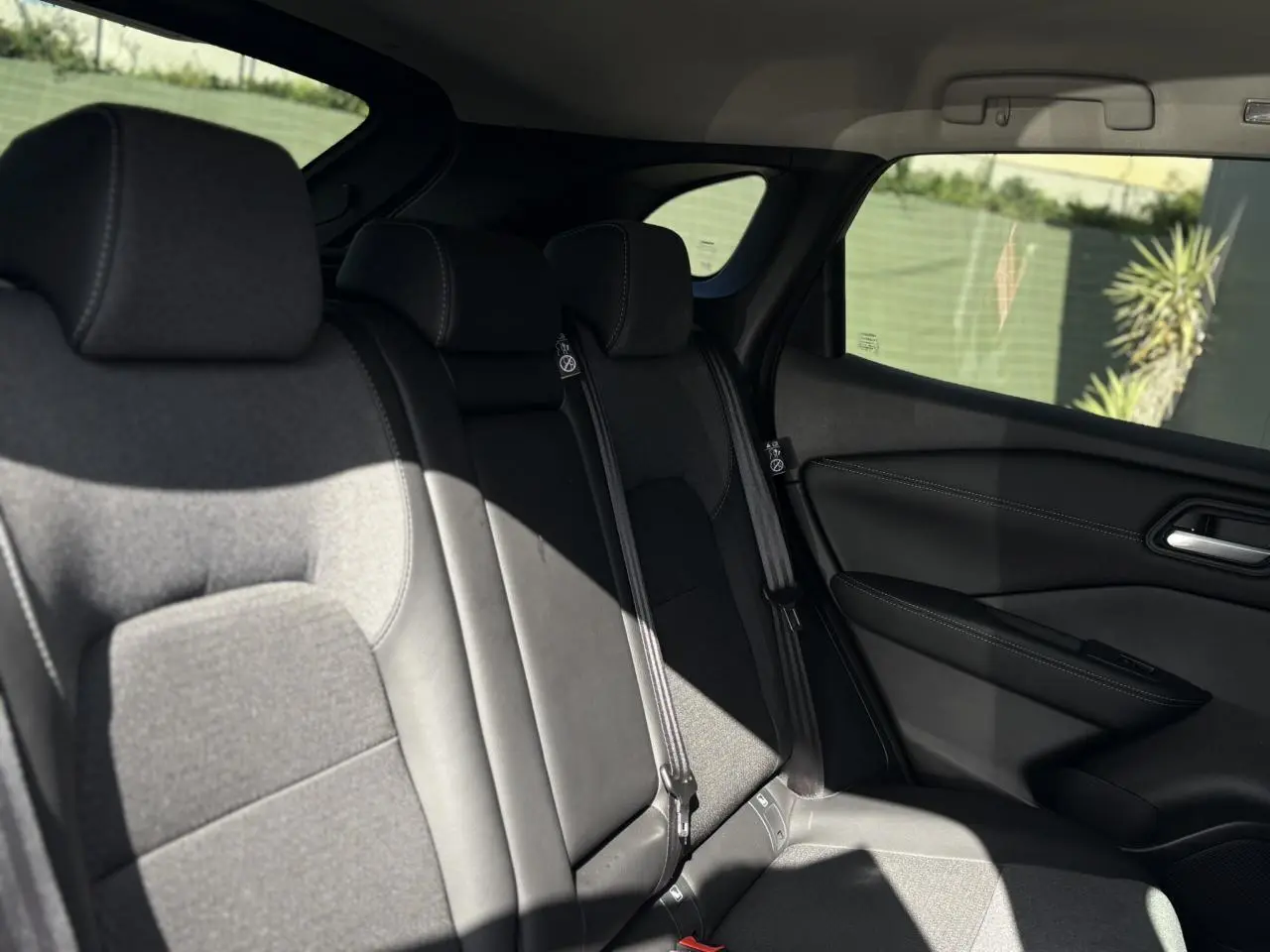 Vue latérale droite des sièges arrière en tissu et cuir noir du Nissan Qashqai 2025 gris Ceramic.