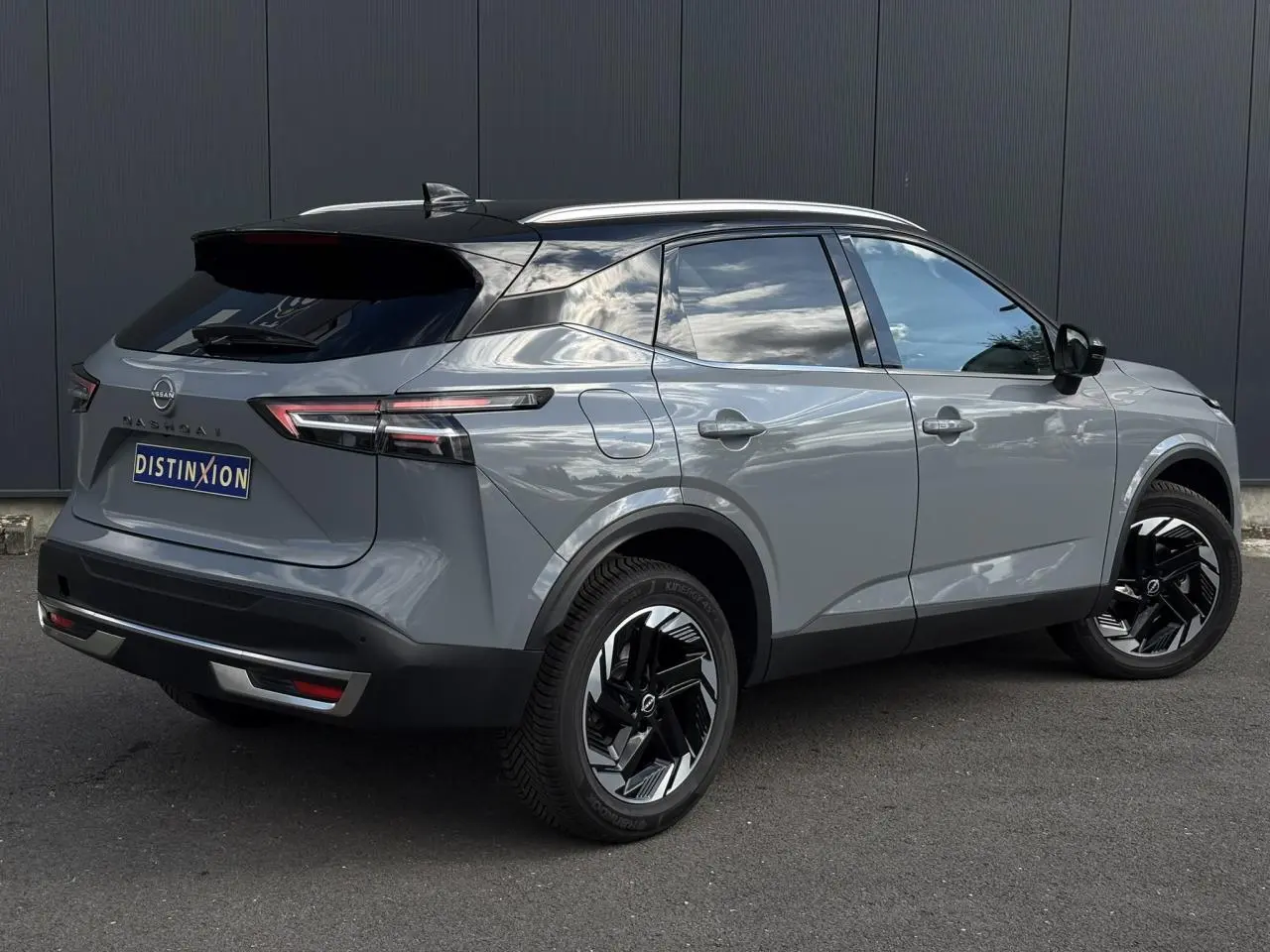 Nissan Qashqai 2025 gris Ceramic en 3/4 arrière droit avec toit noir et jantes alliage noires distinctives.
