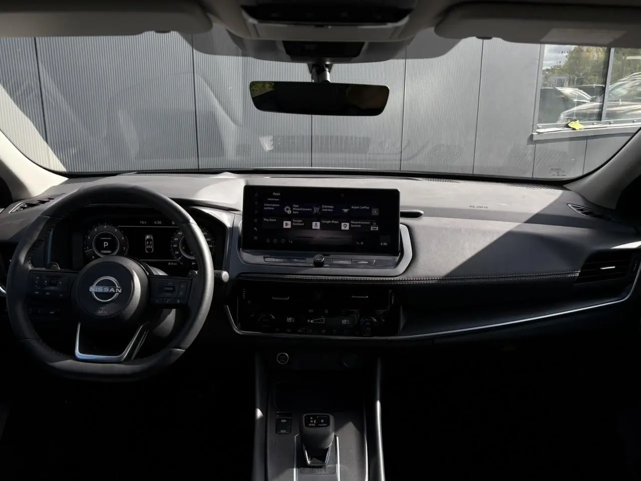 Intérieur du Nissan Qashqai 2025 avec tableau de bord noir, écran tactile central et volant cuir multifonction.