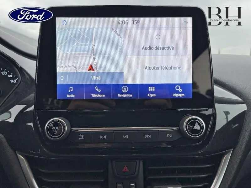 Écran tactile central du Ford Puma 2022 affichant la navigation et commandes audio dans un intérieur noir.