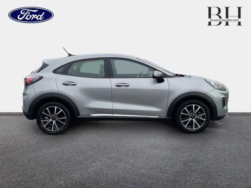 Profil côté gauche d'un Ford Puma gris Solar métallisé avec jantes alliage noires, vue extérieure sur fond neutre.