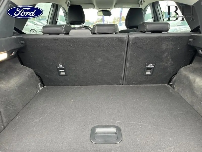 Coffre ouvert vu de l'arrière du Ford Puma gris Solar, banquette arrière en tissu noir relevée.