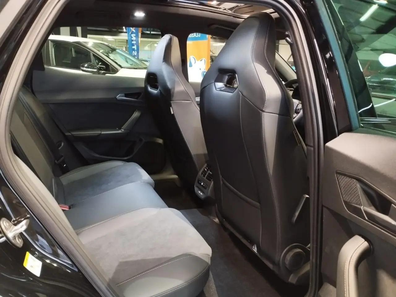 Vue intérieure arrière côté gauche du CUPRA Formentor noir métal, sièges bimatière textile et TEP noir Asphalte.