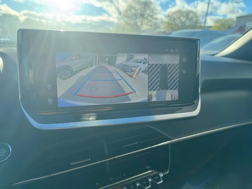 Écran tactile intérieur du Peugeot 2008 Hybrid 136 en vue rapprochée montrant la caméra de recul et l'aide au stationnement.