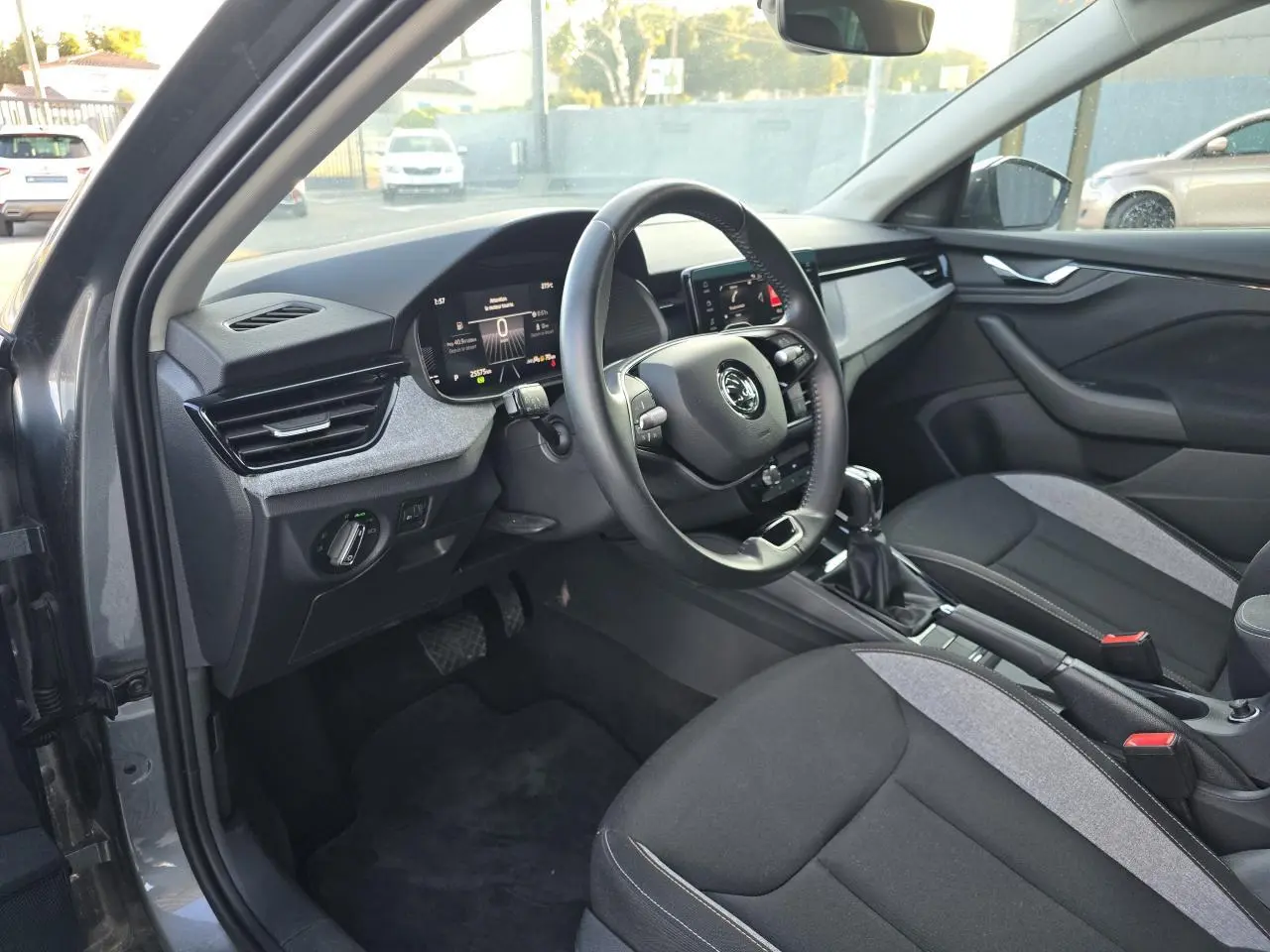 Intérieur avant droit de la Skoda Scala 2024 gris graphite, volant multifonctions et écran digital 8 pouces visible.
