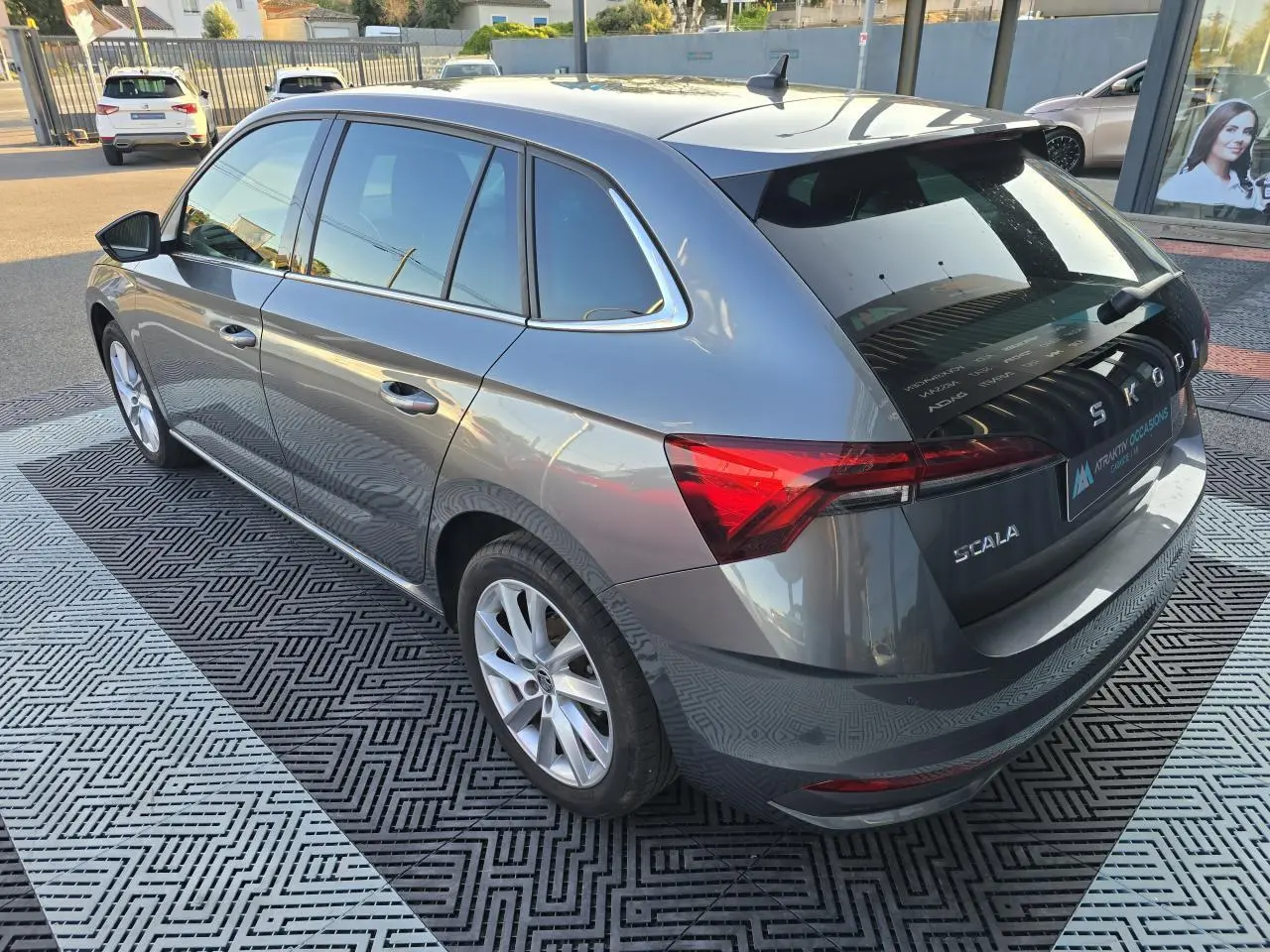 Vue 3/4 arrière droit d'une Skoda Scala 2024 gris graphite métal avec jantes alliage 17 pouces argentées.