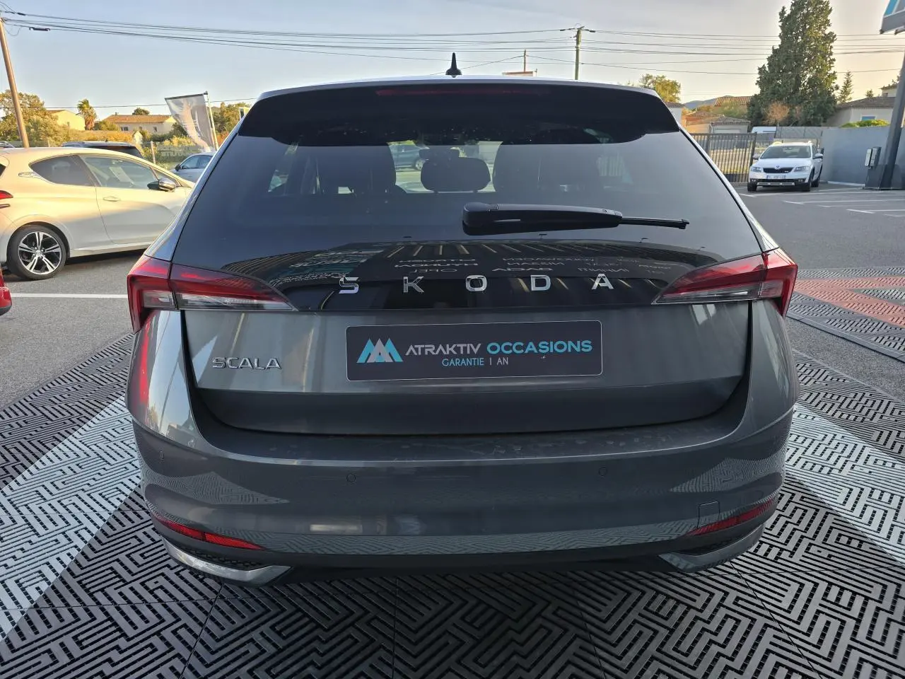 Vue arrière d'une Skoda Scala gris graphite métallisé avec feux arrière LED et logo SKODA visible.
