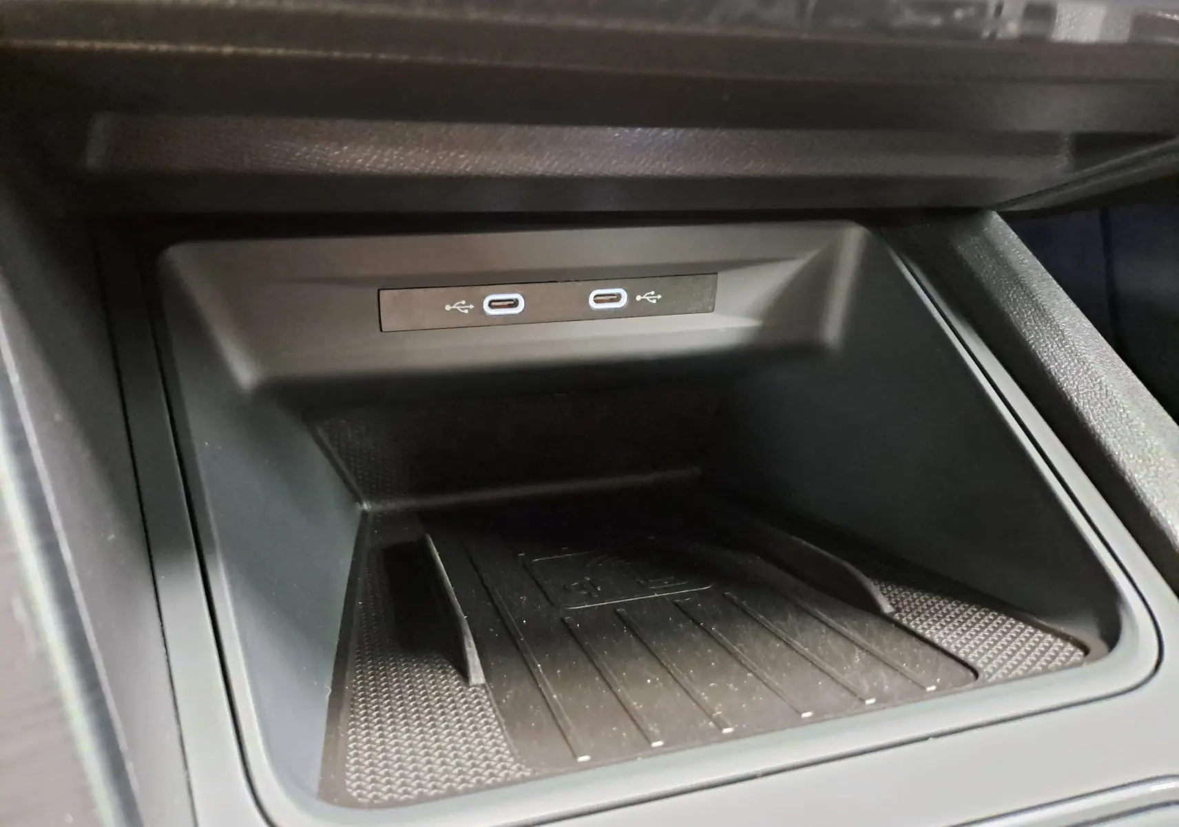 Gros plan sur la console centrale du CUPRA Leon 2024 avec deux ports USB-C et un espace de rangement noir mat.