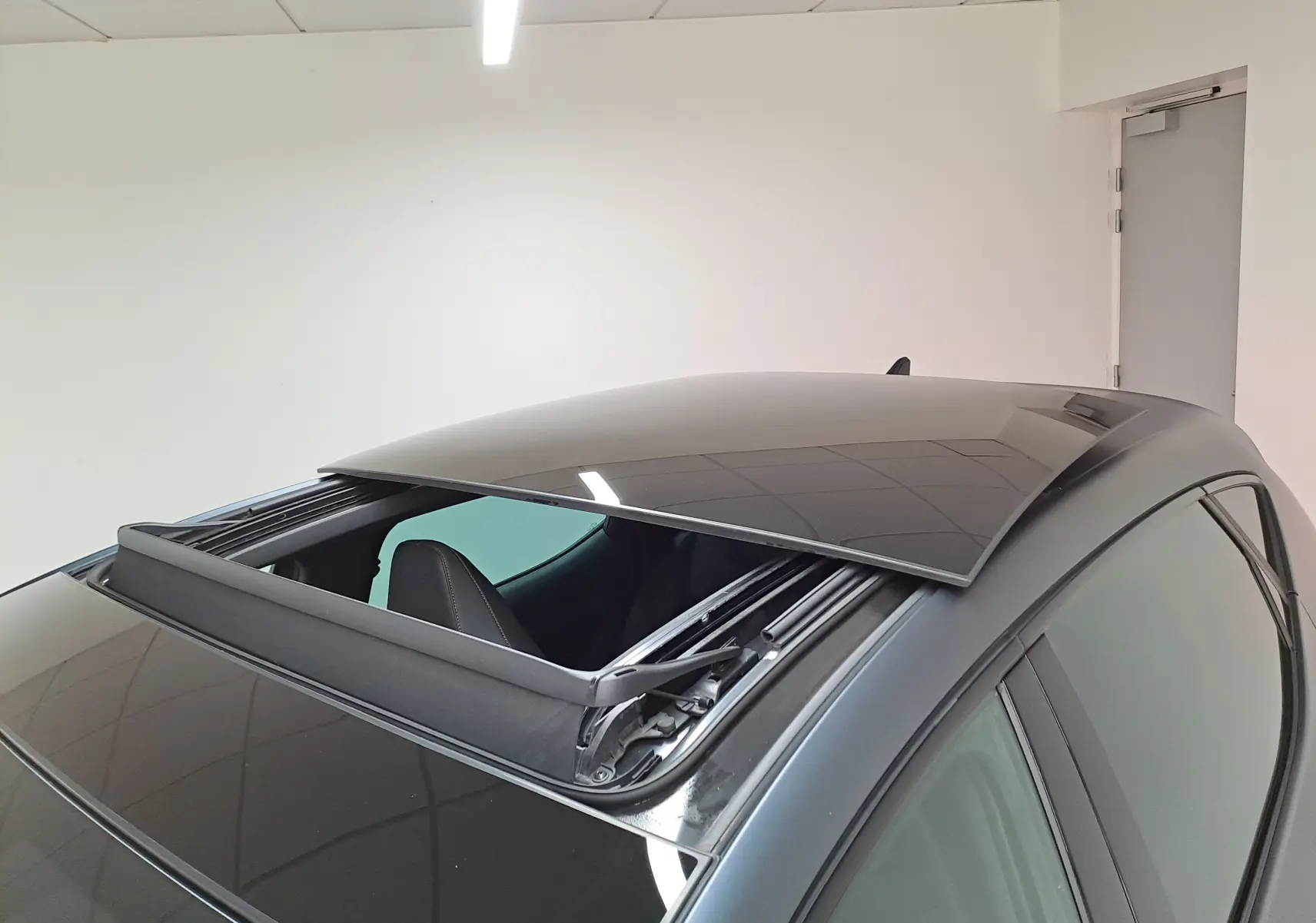 Vue rapprochée du toit ouvrant panoramique ouvert sur une CUPRA Leon 2024 gris magnétique mat.