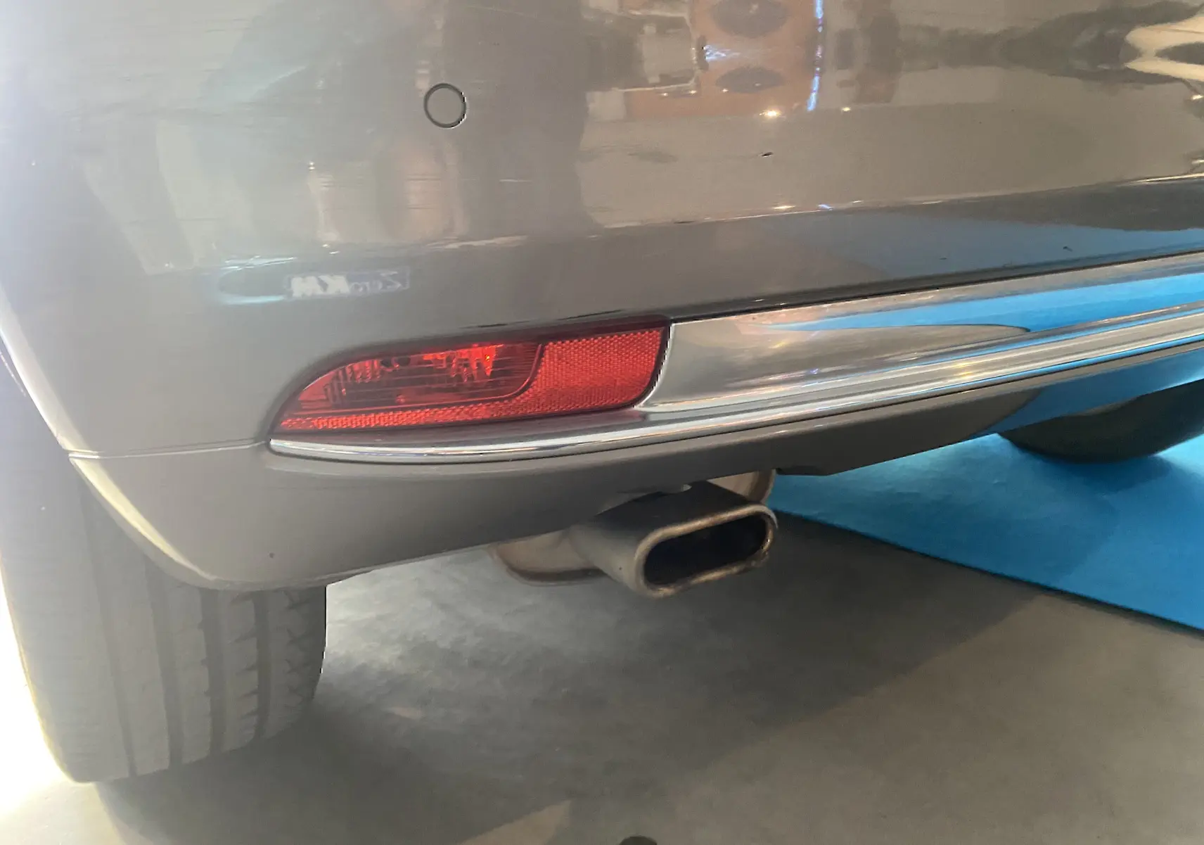 Gros plan sur le pare-chocs arrière gris foncé d'une Fiat 500 2019 avec feu rouge et sortie d'échappement rectangulaire.