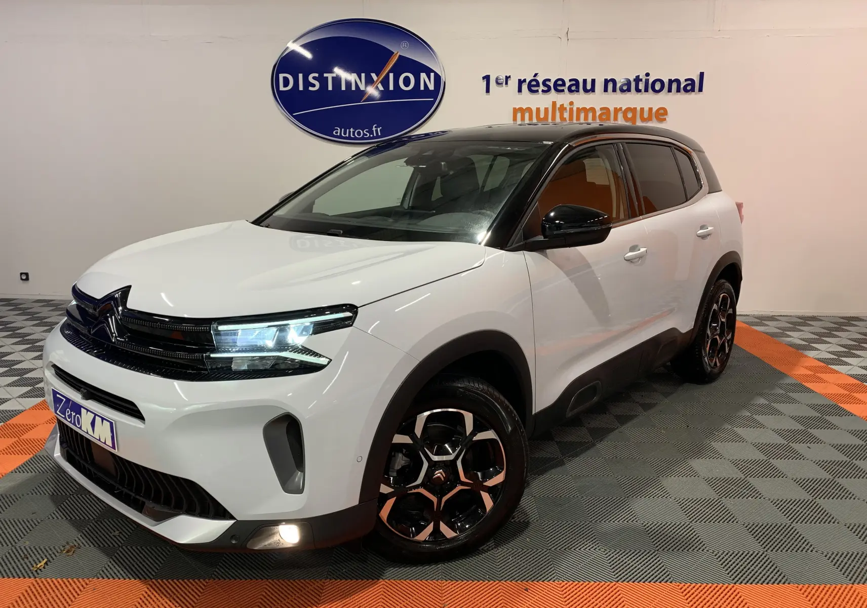Citroën C5 Aircross Hybride blanc en 3/4 avant droit, avec toit noir et jantes bi-ton distinctives.