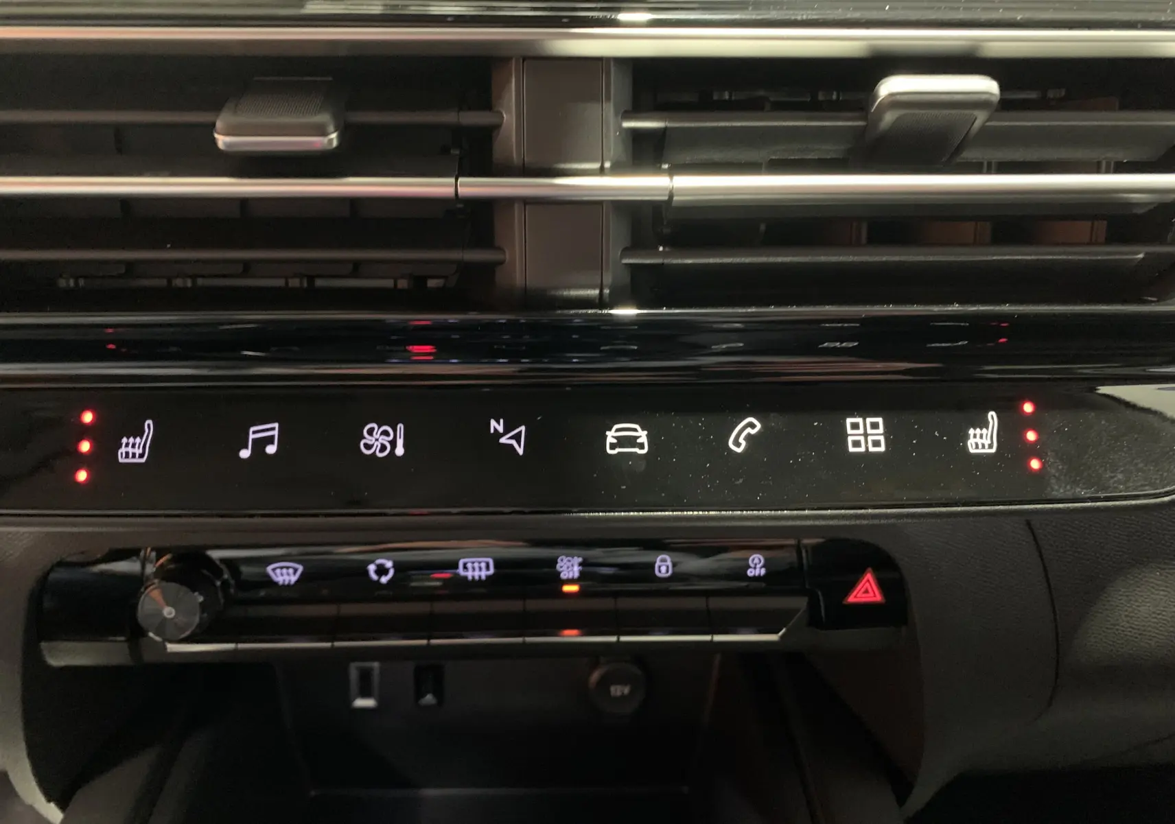 Gros plan sur la console centrale du Citroën C5 Aircross hybride 2024, montrant les commandes climatisation et prises USB.