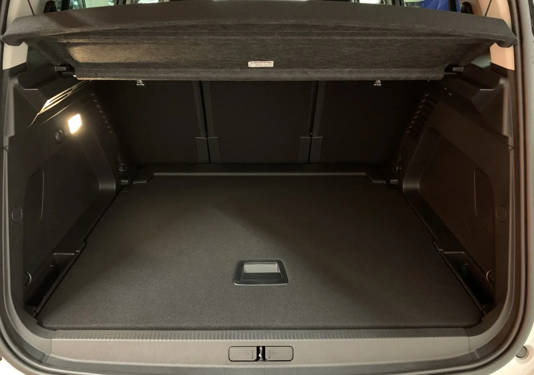 Bouton rouge d'ouverture du coffre et bouton noir à côté sur le panneau intérieur d'une Citroën C5 Aircross hybride blanc 2024.