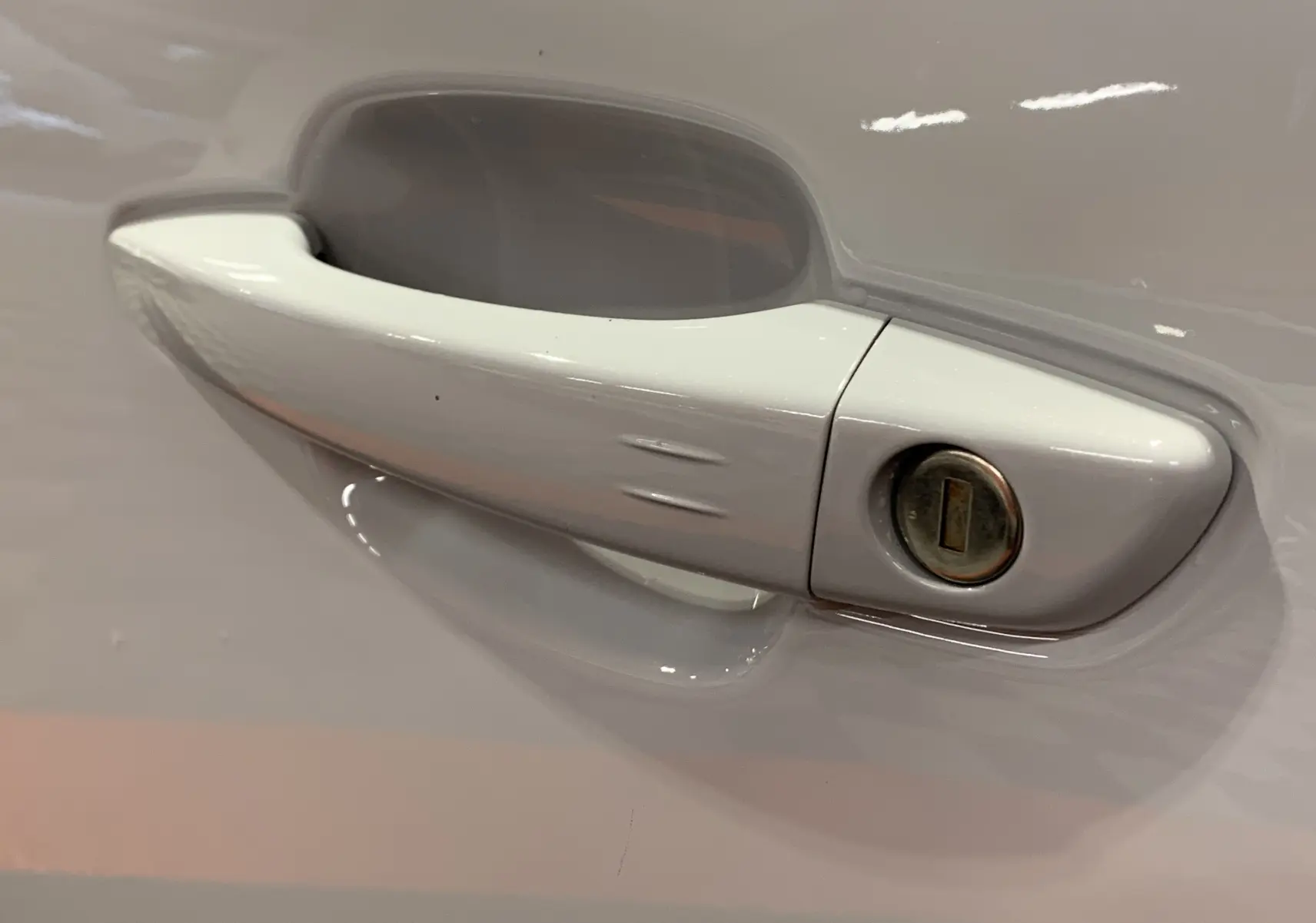 Poignée de porte blanche en gros plan sur le côté gauche d'une Citroën C5 Aircross hybride 2024.