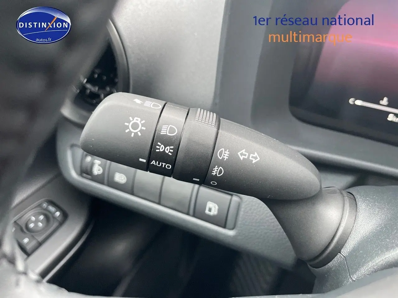 Gros plan sur la commande des phares et clignotants à gauche du volant dans l'habitacle du Toyota C-HR améthyste 2024.